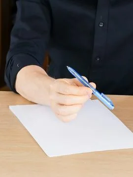 Hand gripping pen ready to write on white paper sheet Stock Photos