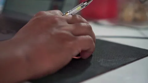 Hand gripping a pen while resting on a computer mouse pad. Stock Footage 348340163