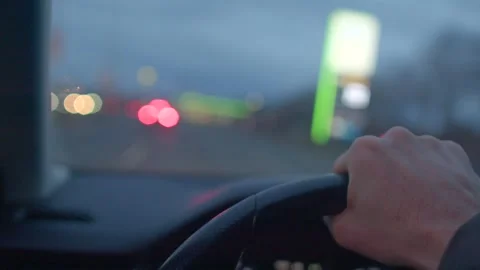 A hand gripping a steering wheel while driving at night with blurred lights in t Stock-Footage 297202000