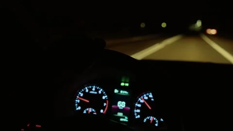 Hand gripping steering wheel while unrecognizable man driving on dark road with Stock Footage 316311988