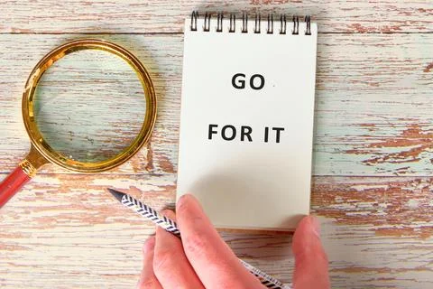 A hand grips a patterned pencil ready to write in a simple notebook that Stock Photos