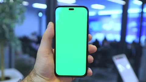 Hand grips phone with solid green display Stock Footage 345377458