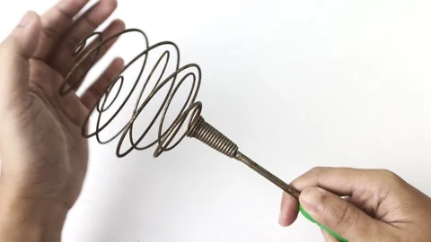 Hand grips a rustic eggbeater with charm Stock Footage 313382188