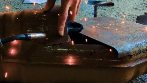 The hand guides the welding tool to connect metal parts Stock Footage 315340278