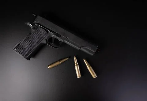 Hand gun with bullets on black background Stock Photos