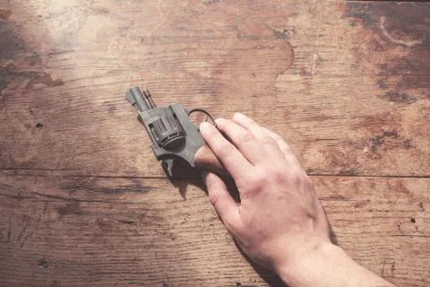 Hand with gun at table Stock-Fotos
