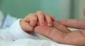 Hand in hand. Mother and newborn daughter in maternity hospital HD Footage