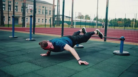 Hand-to-hand push-up. Athletic young man pushing off the ground Stock Footage 153380476