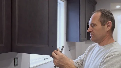 Hand on handle installation door in kitchen cabinet with a screwdriver Vidéo 98013605