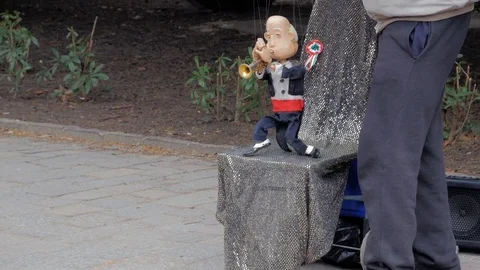 Hand handling at puppet by pulling strings to make the character move. Stock Footage 82517157