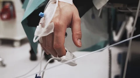 Hand hanging during surgery operation of a sedated deep asleep person. Stock-Footage 120186574