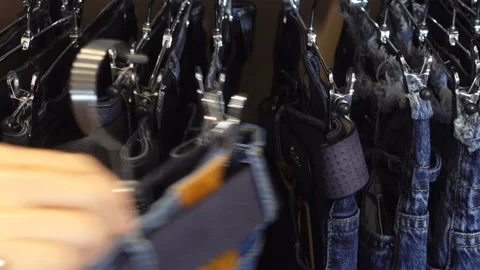 A hand hangs jeans on hanger Stock Footage 153032863