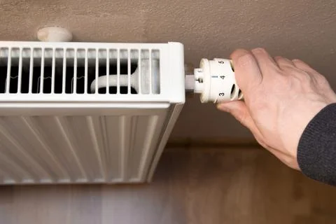 Hand on heater Stock Photos