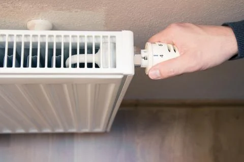 Hand on heater Stock Photos