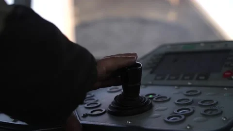 Hand of heavy equipment operator, joystick inside cabin of road paving machine Stock Footage 158040822