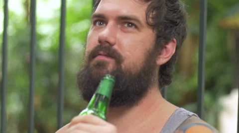 Hand held of bearded man with tattoos talking with a beer in his hand Stock Footage 57095446