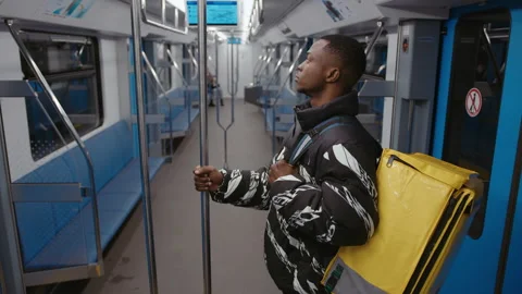 Hand-held camera . An African-American courier rides the subway Stock Footage 239323230