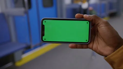 Hand-held camera. Hand of a man with a phone in the subway. Green screen Stock Footage 279726184