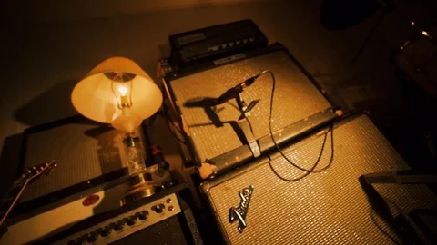 A hand held camera holds on a garage band practice space basking in warm Stock Footage 102828256