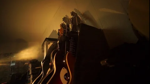 A hand held camera pans across a garage band practice space basking in Stock Footage 102828263