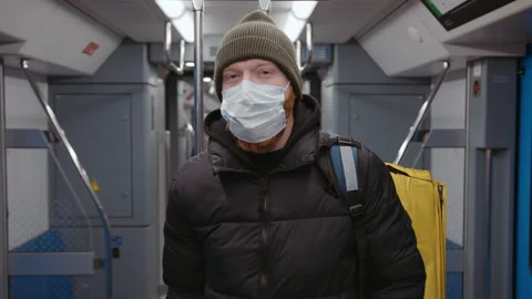 Hand-held camera. Portrait of a courier in a medical mask in the subway Stock Footage 236088541