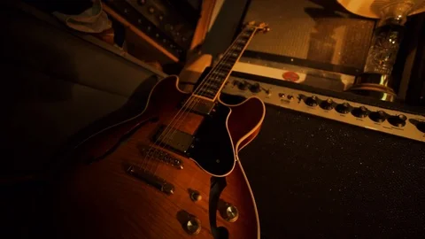 A hand held camera tilts up from a garage band practice space basking in Stock Footage 102828099
