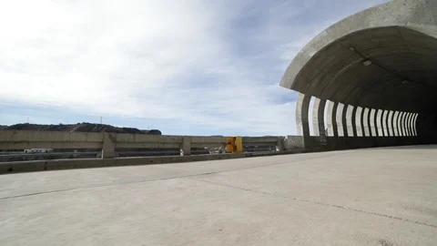 Hand held camera walking towards and getting in a brutalist concrete tunnel 스톡 동영상 95577350