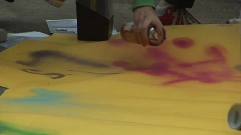 Hand Held CU of Hands Spray Painting onto Paper Stock Footage 273245852