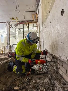 Hand held diamond core drilling in brick wall at construction site during b.. Stock Photos