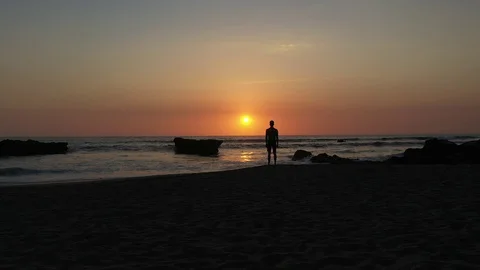 Hand Held Long Shot Of Man Watching Sunset Over The Ocean Stock Footage 120131520