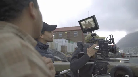Hand held medium shot of a film crew with camera and crew filming on a Stock Footage 121532547