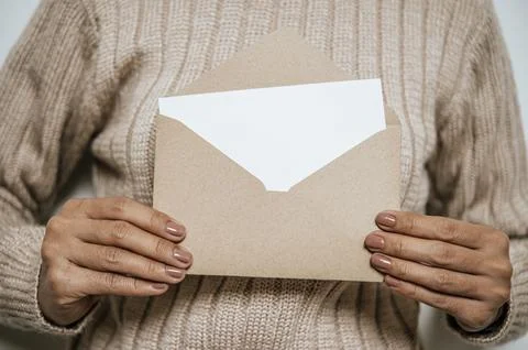Hand held an open card or letter and placed on the chest, the blank cover m.. Stock Photos