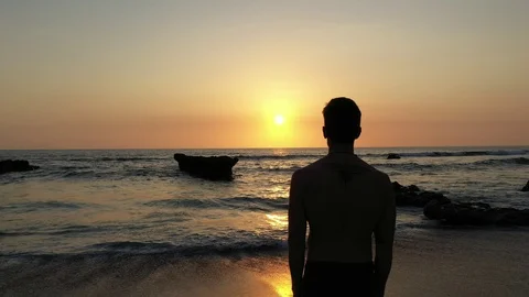 Hand Held Over The Shoulder Of Man Watching Sunset Over The Ocean Stock Footage 120131535
