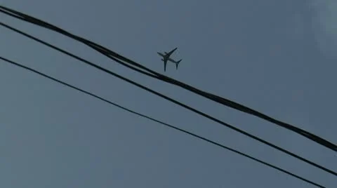 Hand held plane flying  against over head wires Stock Footage 12502539
