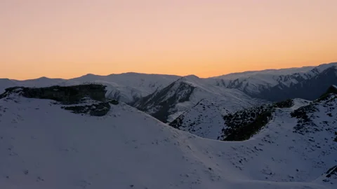 Hand held POV of snow capped mountains pre dawn orange glowing sky Stock Footage 159698015