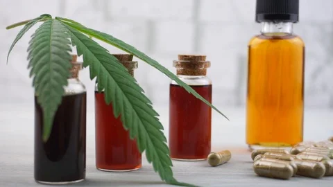 Hand held shot of Cannabis CBD and THC oils and pills Stock Footage 113532107