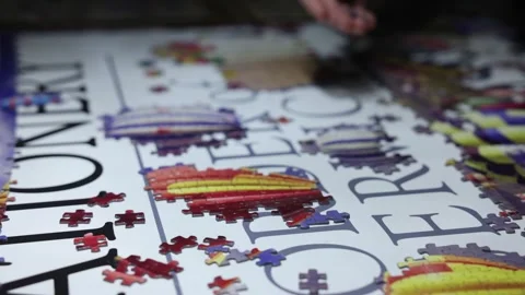 Hand-held shot of jigsaw pieces being joined together to form a picture Stock Footage 294151865