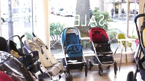 Hand-held shot of a mother looking at strollers Stock Footage 73252913