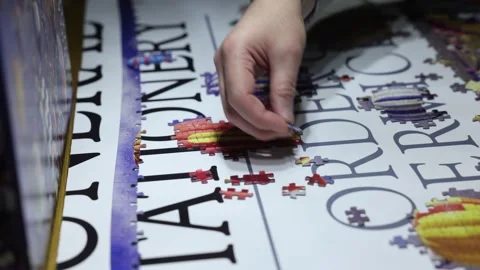 Hand-held shot of a person trying to combine jigsaw pieces together Stock Footage 294151873