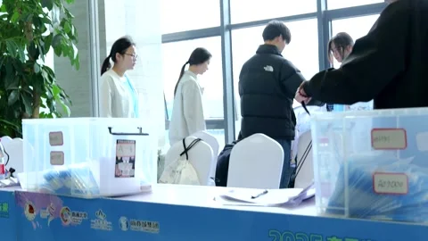 Hand-held shot of registration desk with workers at Beijing E-Town Stock Footage 310306393