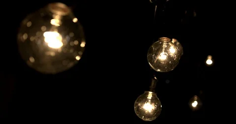 Hand held shot of a string of lightbulbs Stock Footage 98366280