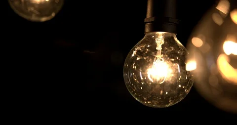Hand held slow motion light bulbs in dark barn Stock Footage 98357305