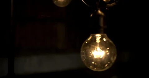 Hand held slow motion light bulb in dark barn Stock Footage 98357716