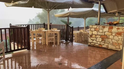 Hand Held View Of Heavy Rain During Tropical Thunderstorm On Patio Area Of Vidéo 217773730