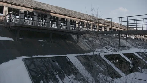 Hand held wide shot of broken out windows on abandoned factory Stock Footage 89945535