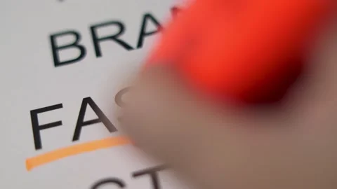 The Hand Highlights the Large Printed Word "FASHION" with an Orange Marker, Clos Stock Footage 139741759