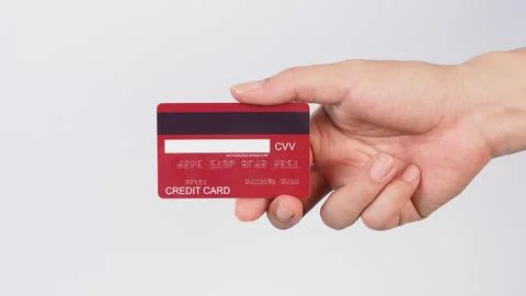 Hand is hold back of red credit card on white background. Stock Photos