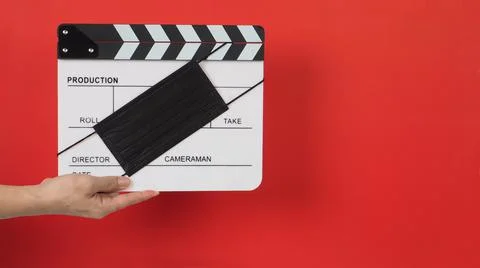 Hand is hold clapper board or movie slate with black face mask. it use in vid Stock Photos