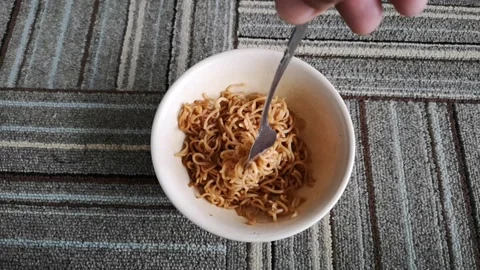 Hand hold a fork while twist hot fried noodles in a bowl Stock Footage 130427403