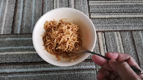 Hand hold a fork while twist hot fried noodles in a bowl Stock Footage 130427482